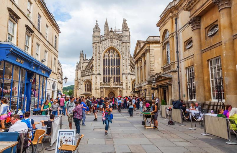 View of Bath Abbey with shops and crowds of people