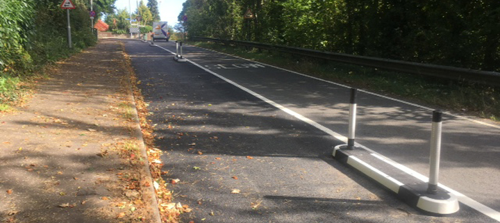 A small island in the road with metal bollards to separate cycles from traffic