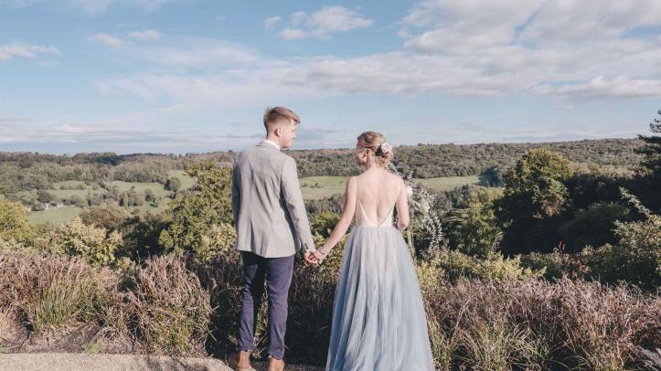 Back of a newly wedded couple with landscape view in front