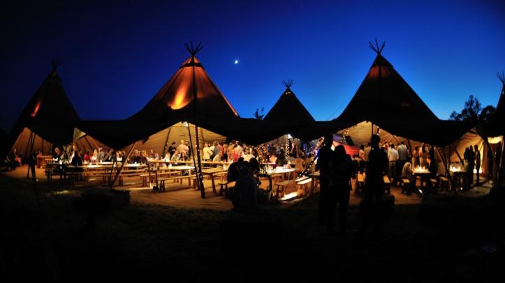 Wedding tents lit up outside at night